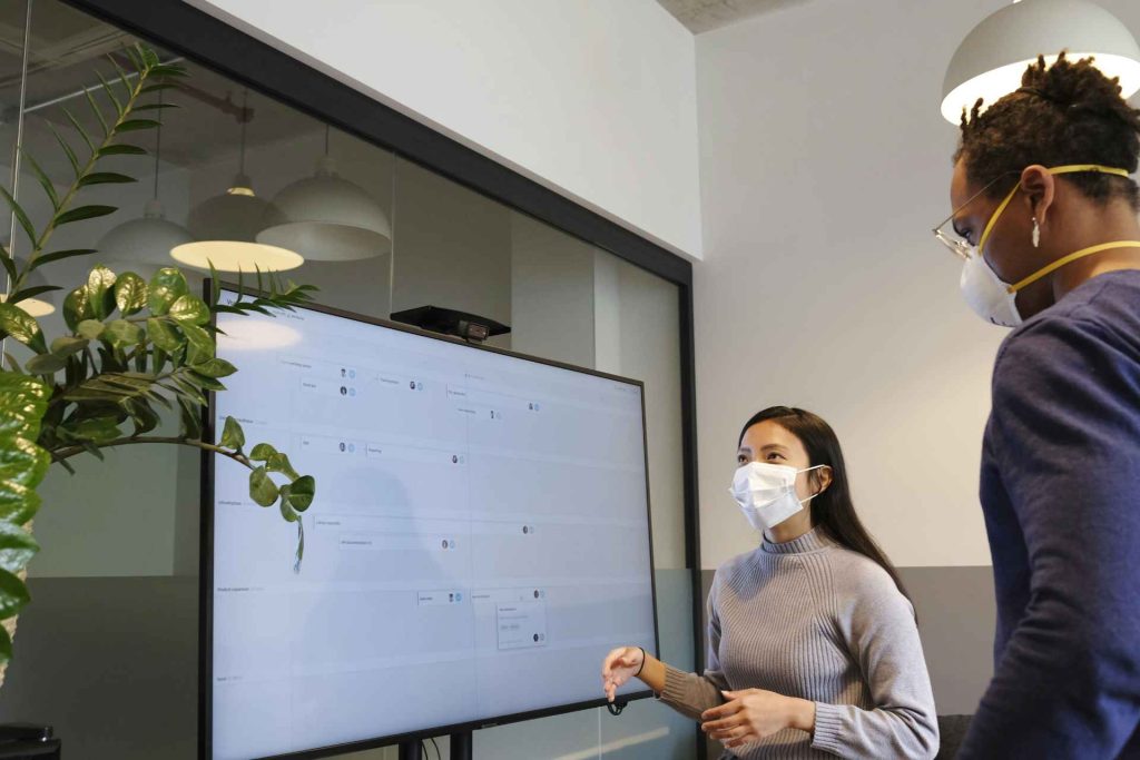 One professional lady wearing face mask and looking on screen